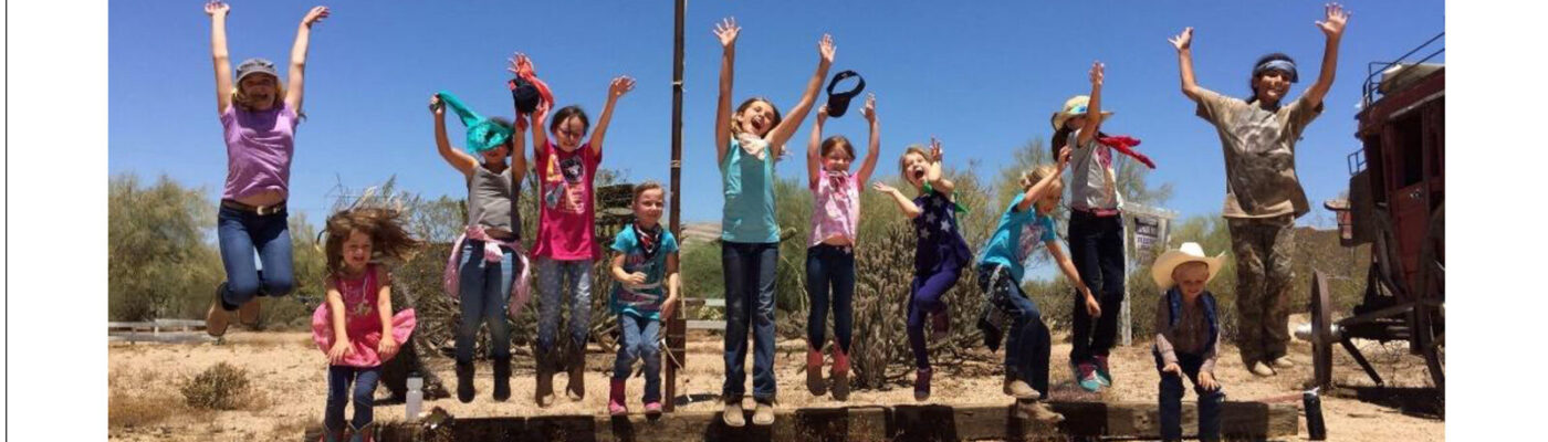 Group photo of kids at 2017 Winter Wild Horse Camp in a desert setting.