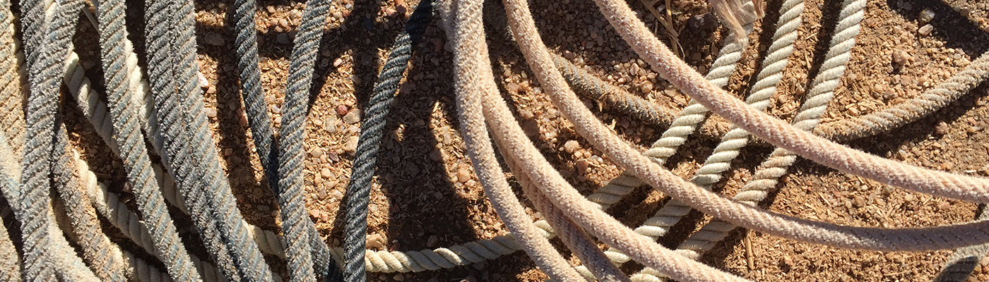 Coiled metal ropes or cables resting on a rough surface.